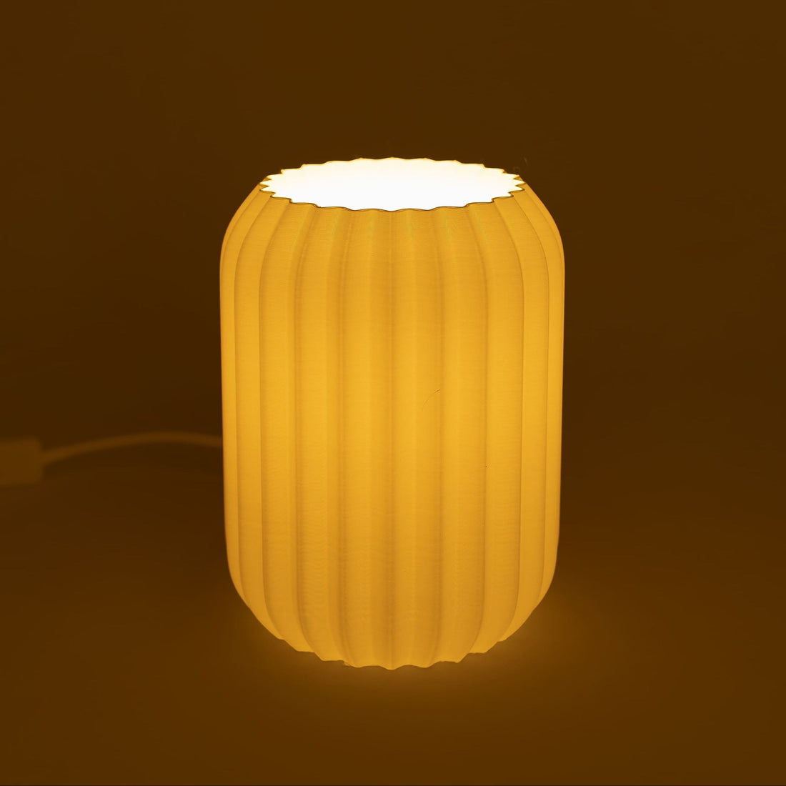 White sculptural table lamp on a bedroom nightstand